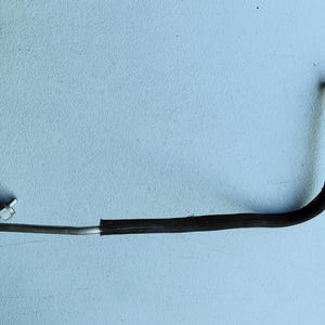 May include: A curved automotive fluid line featuring a metallic silver tube section with a threaded fitting on one end and a black rubber hose section with a metallic connector on the other end, designed for engine or brake system fluid transport.