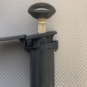 Può includere: Una chiave nera con una lama argentata inserita in un portachiavi in plastica nera.
