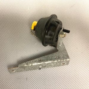 May include: A black metal vacuum pump with a yellow plastic cap and a metal bracket. The pump is attached to the bracket with a chain.