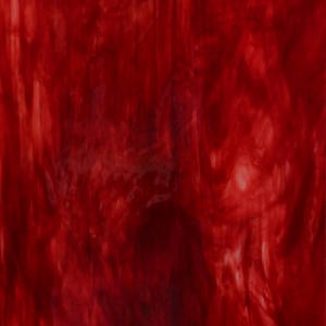 Può includere: Un foglio di vetro colorato rosso con effetto marmoreo. Il vetro ha un colore rosso intenso e ricco con vortici bianchi in tutto.
