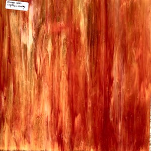 May include: Orange opal stained glass sheet with a swirled pattern of orange, red, and yellow colors.