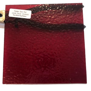 May include: A sheet of medium dark red glass with a textured surface. The glass is labeled "Medium Dark Red Corelle Classic Wissmach from Mixed Bay Mosaics".
