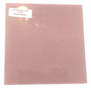May include: A square sheet of Classic Violet Opaque Fusible Wissmach glass in a muted mauve color. A white sticker in the upper left corner reads "Classic Violet Opaque Fusible Wissmach" and "From Mixed Bag Mosaics."