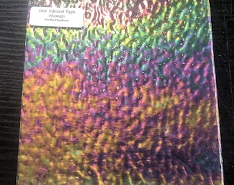 May include: Clear iridescent ripple glass with a textured surface. The glass has a rainbow of colors, including yellow, green, purple, and pink. The label reads "Clear Iridescent Ripple Wissmach".
