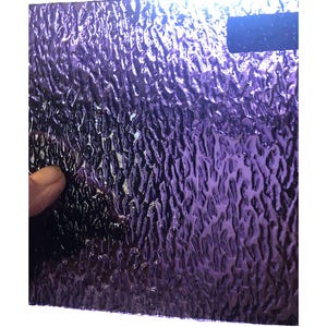 May include: A sheet of textured glass with a purple iridescent finish. The glass has a rippled pattern.