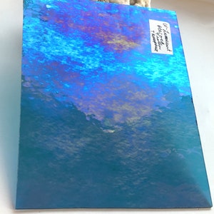 May include: A sheet of iridescent blue and purple holographic film with the text "U-Zamount Photo-satin Treatment" on the right side.
