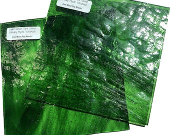 May include: Three sheets of green streaky glass, labeled "Light Green Dark Green Streaky Mystic Wissmach from Mind Bag Mosaics".