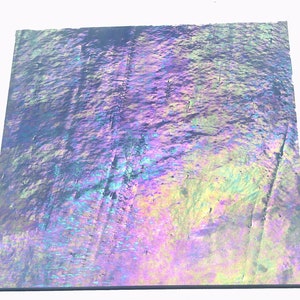 May include: A sheet of iridescent holographic paper with a textured surface. The paper has a blue, purple, green, and yellow color scheme.