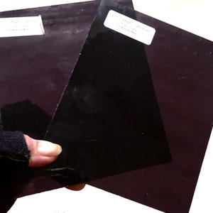 Pu&ograve; includere: Due pezzi di vetro colorato di viola scuro, uno leggermente pi&ugrave; scuro dell'altro. Ogni pezzo ha un'etichetta bianca con il testo "25% Tint" e "25% Tint" stampato su di essi.