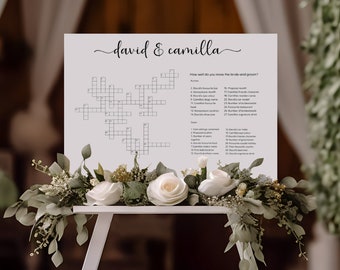 May include: A white sign with a crossword puzzle and a list of questions about the bride and groom. The sign is titled "david & camilla" and says "How well do you know the bride and groom?"