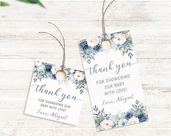 Op de afbeelding: Twee blauwe en witte bloemige bedankkaartjes met de tekst "Bedankt voor het vieren van onze baby met liefde! Liefs, Abigail".