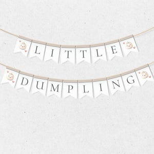 May include: White banner with the text "LITTLE DUMPLING" in black letters. Each letter is on a separate white triangle flag with a small pink heart and a cartoon dumpling with a face on each end.