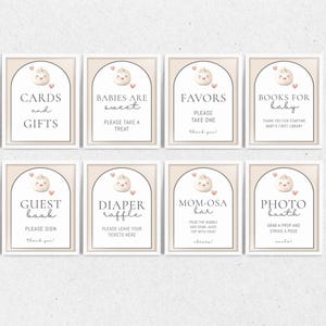 May include: Eight framed signs with text for a baby shower. The signs have a light beige background and white frames. Each sign has a dumpling graphic with a heart. Text includes "Cards and Gifts", "Babies are Sweet", and "Photo Booth".