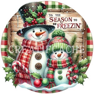 May include: A festive Christmas illustration depicts two snowmen. One wears a top hat and scarf, the other a knit cap and scarf. The text reads "Tis the Season to be Freezin'." Holly and candy canes add festive touches.