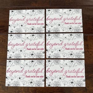 May include: Six white cards with a floral design and the phrases "beyond grateful" and "Thank you for your order" in a burgundy script font. The floral design features black line drawings of various flowers.