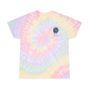Op de afbeelding: Een pastelkleurig tie-dye T-shirt met een spiraalpatroon in roze, geel, paars en groen. Het shirt heeft een afbeelding op de linkerbovenborst met de woorden "Dead Up Dream" en een schedel met een bliksemschicht.
