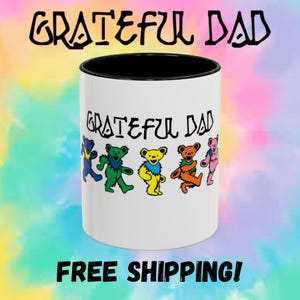 May include: White ceramic mug with a black rim and handle. The mug features a colorful graphic of dancing bears and the text "Grateful Dad".