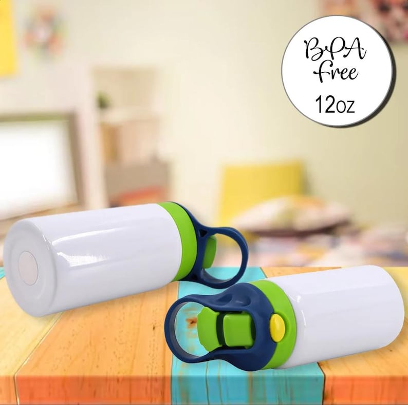 May include: Two white water bottles with green and blue detailing. Each bottle has a flip-top lid and a handle. The bottles are BPA-free and hold 355ml. They are on a colourful wooden surface.