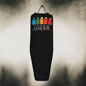 May include: Black K-II EMF meter with a colorful graphic of stick figures and the text "1.5 2.5 10 20+ mG K-II EMF METER". The meter is hanging from a black cord.