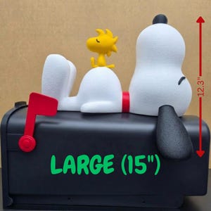 May include: A black mailbox with a red flag, topped with a white dog figure and a yellow bird figure. The mailbox features the text LARGE (15") in green, and a red arrow indicates a height of 12.3 inches next to the white dog figure.