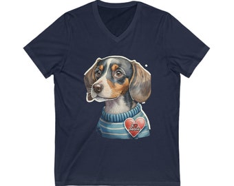 May include: A navy blue v-neck t-shirt with a cartoon illustration of a dachshund wearing a blue and white striped sweater. The dachshund has brown, black, and white fur and is wearing a red heart with the text "I love Mom" on it.