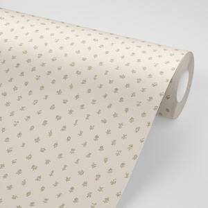May include: A roll of wallpaper featuring a cream-colored background with a repeating pattern of small, delicate green sprigs and tiny pink flower buds arranged in a consistent, evenly spaced grid across the entire surface of the paper.