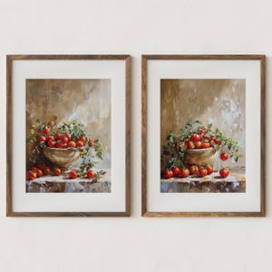 May include: Two framed prints of still life paintings featuring bowls overflowing with red tomatoes and green vines. The paintings are set against a textured beige background.