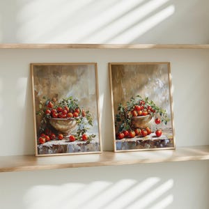 May include: Two framed paintings of still life arrangements featuring bowls overflowing with red tomatoes and green leaves against a beige background.