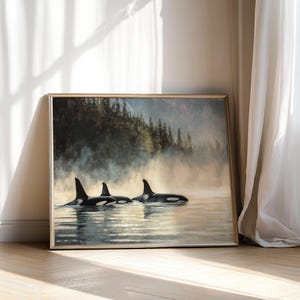 May include: A framed painting depicting three orcas swimming in a misty, forested landscape. The orcas are black and white, and the water is a light blue. The forest is a dark green, and the mist is a light grey.