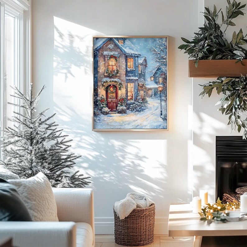 May include: A framed painting of a snow-covered village scene with a house decorated for Christmas. The house has a red door and a wreath with a red bow. The windows are lit up and there is snow falling in the background.