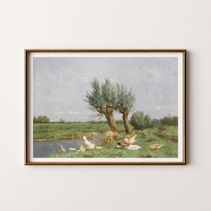Op de afbeelding: Een schilderij van een landelijk landschap met een vijver en een groep eenden. De eenden zijn wit en bruin en zwemmen in de vijver. Er zijn twee wilgenbomen op de achtergrond. De lucht is lichtblauw met wat wolken.