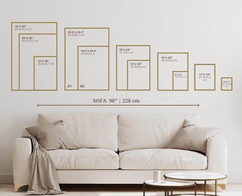 May include: A diagram showing different sizes of picture frames, with measurements in inches and centimeters, displayed on a white wall above a white sofa. The text "SOFA 90" 228 cm" is printed below the frames.