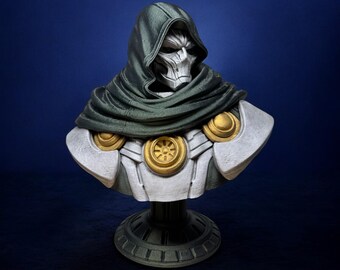 May include: A bust of Doctor Doom, a Marvel Comics supervillain, wearing a green hooded cloak and a silver and gold armor. The bust is on a black stand.