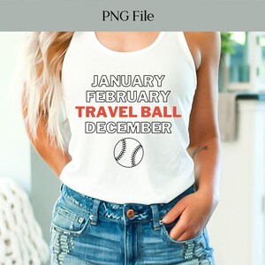 Pode incluir: Top branco com as palavras "JANUARY FEBRUARY TRAVEL BALL DECEMBER" em texto preto e vermelho, com um gráfico de baseball. A pessoa está usando shorts jeans.