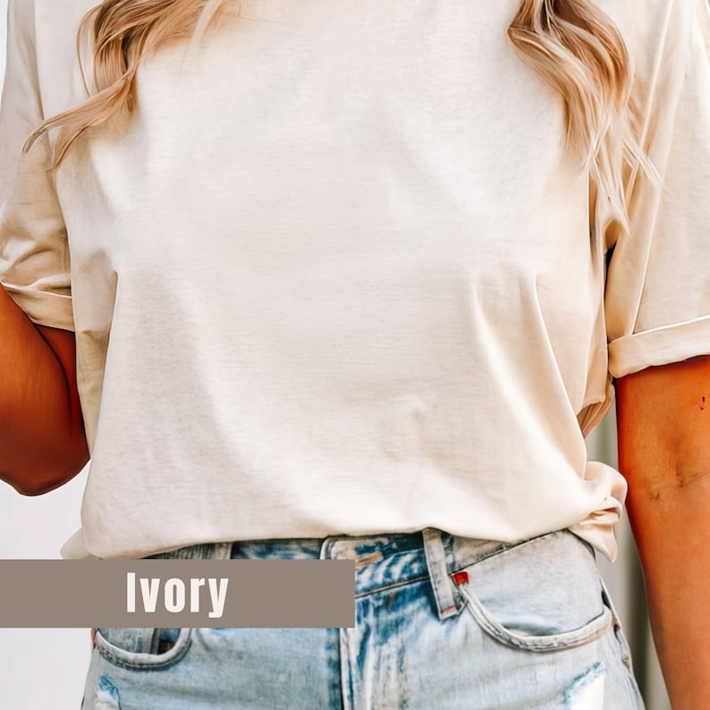 May include: Ivory-colored t-shirt with rolled-up sleeves. The shirt is paired with light-wash denim jeans. The word "Ivory" is displayed in a rectangular banner at the bottom of the image.