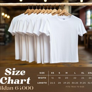 May include: Several white Gildan 64000 t-shirts hanging on wooden hangers. A size chart is displayed below, showing measurements in inches for width and length, ranging from XS to 3XL. The shirts are displayed against a blurred background.