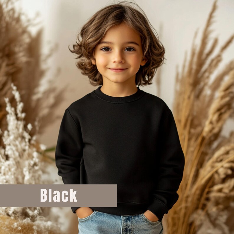 May include: A black crew neck sweatshirt. The word "Black" is displayed on a tan rectangular label at the bottom of the image. The sweatshirt is worn by a child with brown hair and blue jeans.