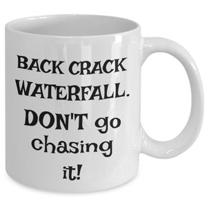 May include: White ceramic coffee mug with black text that reads "Back crack waterfall. Don't go chasing it!"