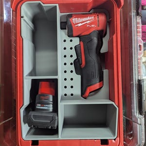 May include: A red and black Milwaukee FUEL impact driver and battery are stored in a red and grey plastic case. The case has a clear lid and is divided into compartments. The battery is labelled "M12 HIGH OUTPUT".