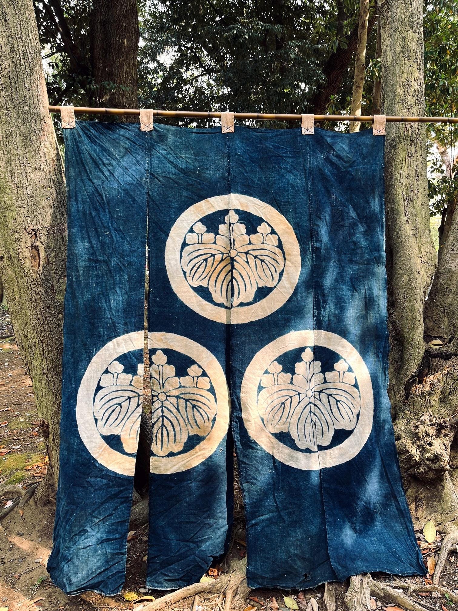 Japanese vintage indigo dyed cotton tsutsugaki noren shop curtain with a family crest, Meiji era.