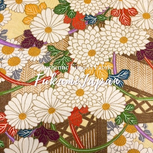 May include: A textile featuring a dense pattern of white chrysanthemums with yellow centers, interspersed with green, red, and purple leaves. The background displays a gold geometric lattice design. Text reads: Authentic Kimono Fabric Fukami Japan.