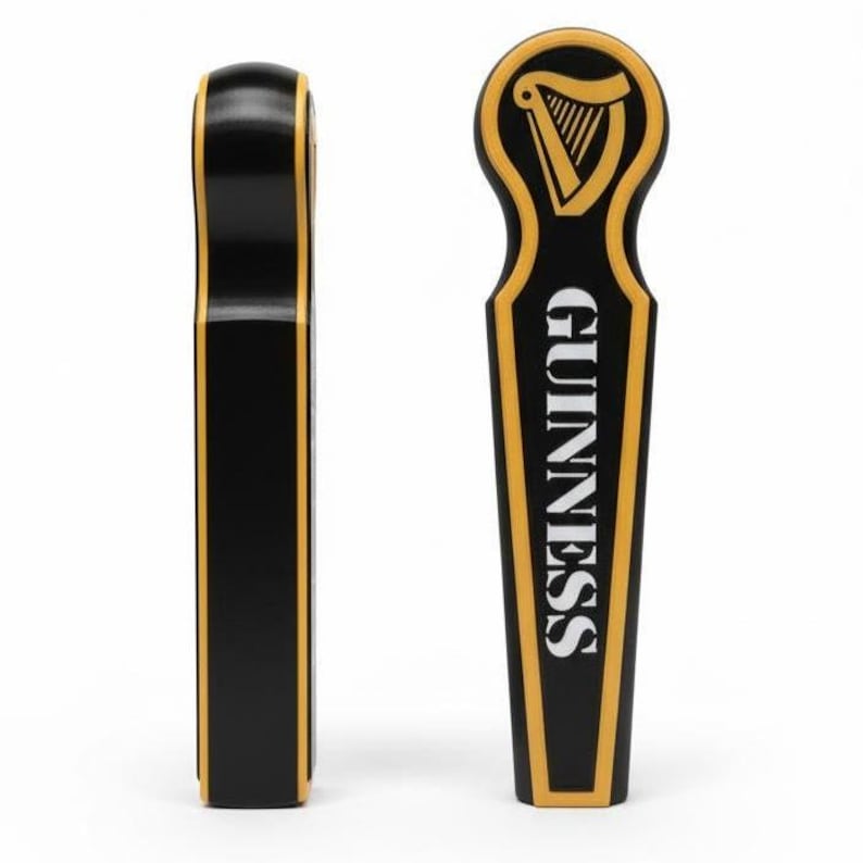 May include: Two black and gold Guinness tap handles. One handle is shown from the side, the other features the Guinness logo and the word "GUINNESS" in white lettering. The handles are made of a glossy material.