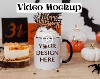 May include: White ceramic mug with a black handle, featuring the text "YOUR DESIGN HERE" and a small spider graphic. The mug is topped with whipped cream and a wooden "Happy Halloween" sign. The mug is surrounded by small white and orange pumpkins and black spiders.