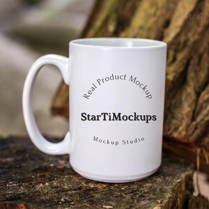 May include: White ceramic mug with a black handle. The mug has the text "Real Product Mockup" and "StarTiMockups Mockup Studio" printed on it.