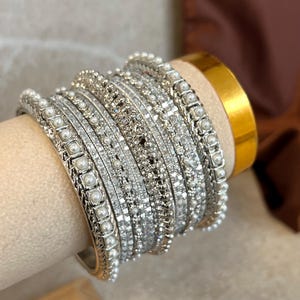 May include: A set of three ceramic mugs with a speckled, matte finish. The mugs are in shades of cream, light gray, and dark gray. Each mug has a simple, minimalist design, perfect for coffee or tea.