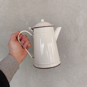 Puede incluir: Tetera de esmalte blanco con borde marrón y asa. La tetera tiene un diseño clásico y es perfecta para preparar té.