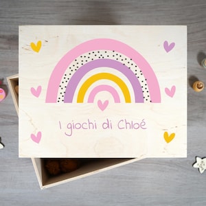Peut inclure: Boîte de rangement en bois avec un arc-en-ciel rose, violet et jaune, orné de cœurs roses et jaunes. Le texte "I giochi di Chloé" est inscrit sur la boîte dans une police manuscrite.