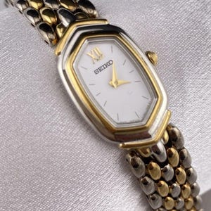 Reloj Seiko vintage en tono dorado y plateado con forma de diamante, delicado y elegante, pequeño