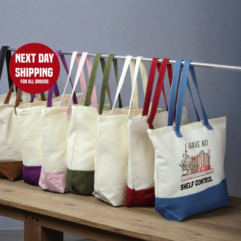A row of colorful tote bags hanging on a rack, with a sign indicating next day shipping for all orders.