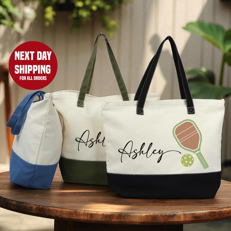 two tote bags with personalized names on them, placed on a wooden table.